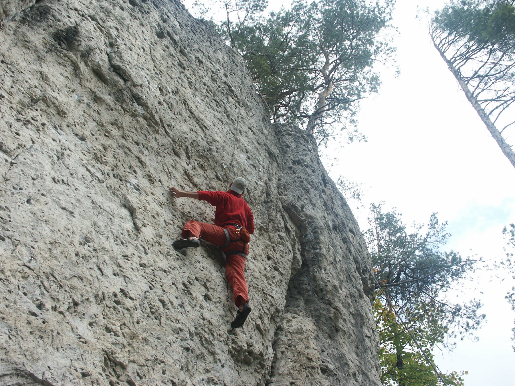 Das Foto zeigt einen Kletterer an einer Felswand irgendwo in der Fränkischen Schweiz 